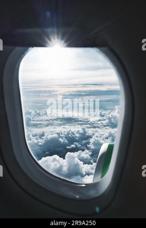 Eine vertikale Aufnahme der Wolkenansicht aus einem Flugzeugfenster Stockfoto