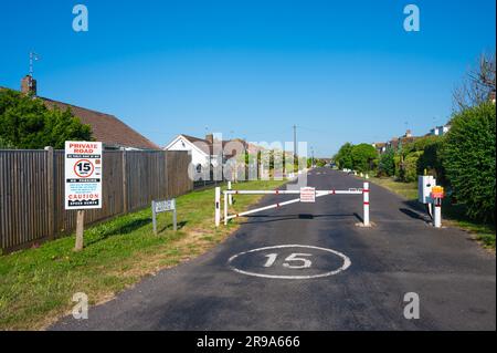 Eingezäunter Eingang mit geschlossenem Tor zu einer privaten Straße mit 15MPH Geschwindigkeitsbegrenzung an der Cudlow Avenue, Rustington, West Sussex, England, Großbritannien. Stockfoto