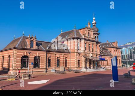 Delft, Niederlande, 9. Oktober 2021: Der alte Bahnhof von Delft, das heutige Restaurant Pavarotti neben dem neuen Bahnhof und dem Rathaus von Delft, Th Stockfoto