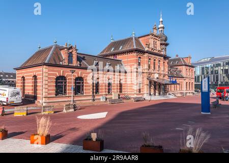 Delft, Niederlande, 9. Oktober 2021: Der alte Bahnhof von Delft, das heutige Restaurant Pavarotti neben dem neuen Bahnhof und dem Rathaus von Delft, Th Stockfoto