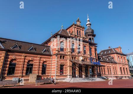 Delft, Niederlande, 9. Oktober 2021: Der alte Bahnhof von Delft, das heutige Restaurant Pavarotti neben dem neuen Bahnhof und dem Rathaus von Delft, Th Stockfoto