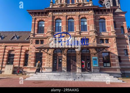 Delft, Niederlande, 9. Oktober 2021: Der alte Bahnhof von Delft, das heutige Restaurant Pavarotti neben dem neuen Bahnhof und dem Rathaus von Delft, Th Stockfoto