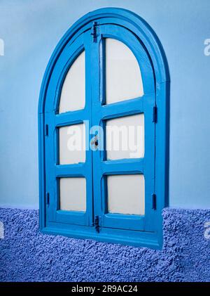 Eine Außenwand und Holzbogenfenster sind in drei Blautönen gehalten und repräsentieren die Blaue Stadt, Chefchaouen, Marokko Stockfoto