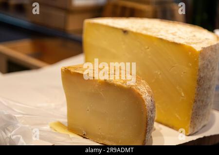 Cheesemonger Cutting Wheel of 7 Monate aged Cloth Bound Cheddar, Grafton Village Cheese Shop, Grafton, Vermont, USA Stockfoto