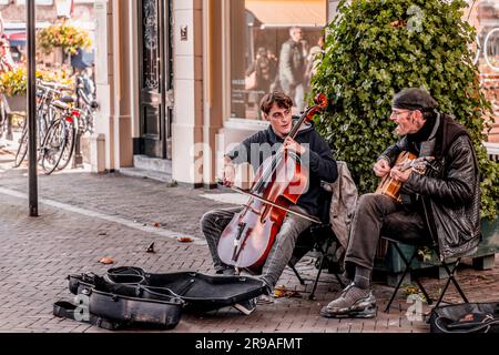 Utrecht, NL - 9. Okt 2021: Zwei Straßenmusiker treten im Stadtzentrum von Utrecht auf. Stockfoto