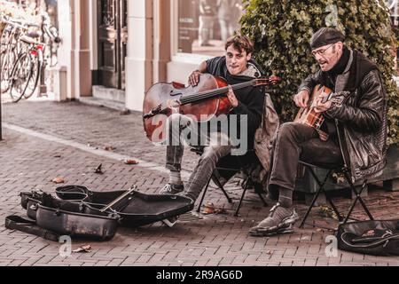 Utrecht, NL - 9. Okt 2021: Zwei Straßenmusiker treten im Stadtzentrum von Utrecht auf. Stockfoto