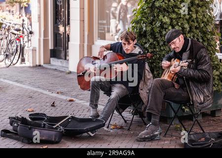 Utrecht, NL - 9. Okt 2021: Zwei Straßenmusiker treten im Stadtzentrum von Utrecht auf. Stockfoto