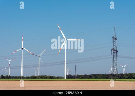 Freileitungen und Windturbinen auf einem Feld in Deutschland Stockfoto