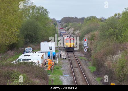 DB Cargo Rail UK-Diesellokomotive der Klasse 66, die einen Zug leerer Zuschlagwagen vom HS2-Bauterminal am Quainton-Eisenbahnkopf wegtransportiert Stockfoto