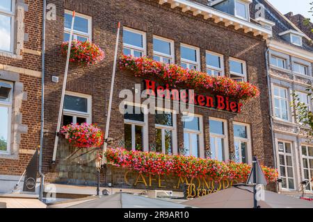 Maastricht, Niederlande - 16. Oktober 2021: Beschilderung der niederländischen Biermarke Heineken, dem größten Bierunternehmen der Niederlande. Wand eines Cafés oder Kneipenservices Stockfoto