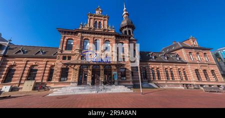 Delft, Niederlande, 9. Oktober 2021: Der alte Bahnhof von Delft, das heutige Restaurant Pavarotti neben dem neuen Bahnhof und dem Rathaus von Delft, Th Stockfoto