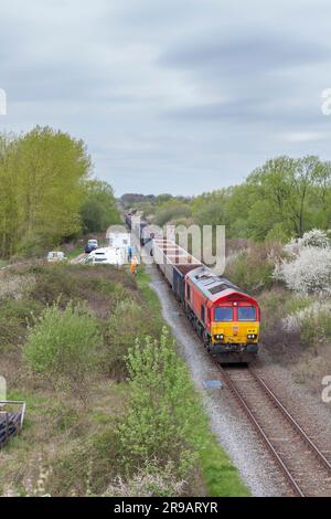 DB Cargo Rail UK-Diesellokomotive der Klasse 66, die einen Zug leerer Zuschlagwagen vom HS2-Bauterminal am Quainton-Eisenbahnkopf wegtransportiert Stockfoto
