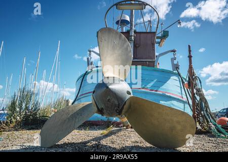 Fischerboot mit einem großen Propeller an Land bei einem Hafen im Sommer Stockfoto