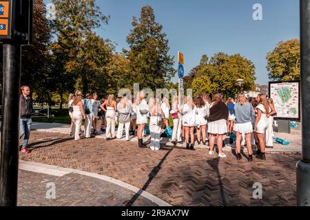 Utrecht, NL - 9. Okt 2021: Eine Gruppe junger, weiß gekleideter Studentinnen versammelte sich zu einem gesellschaftlichen Anlass in Utrecht, Niederlande. Stockfoto