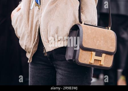 Paris, France - October, 3, 2021: woman wears handbag Velours Cotele Swift Constance 24 Tabac Camel Ebene Stockfoto