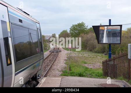 Der Zug der Chiltern Railways Klasse 168 spiegelt sich im Spiegel für den Betrieb nur für Fahrer am Bahnhof Little Kimble wider (Linie von Aylesbury nach Princess Risborough) Stockfoto