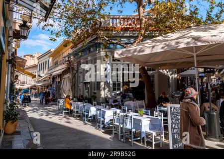Athen, Griechenland - 25. November 2021: Sitzplätze im Freien in den traditionellen griechischen Restaurants in den zentralen Straßen von Athen, Griechenland. Stockfoto