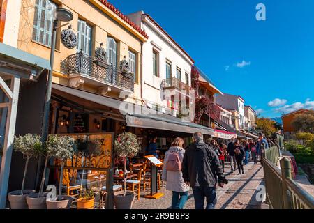 Athen, Griechenland - 25. November 2021: Sitzplätze im Freien in den traditionellen griechischen Restaurants in den zentralen Straßen von Athen, Griechenland. Stockfoto