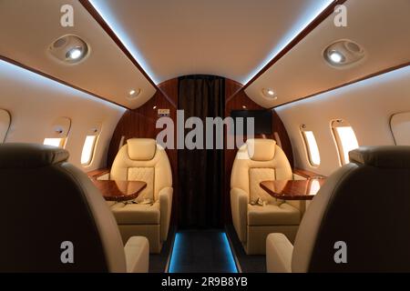 Innenansicht mit breitem Blick auf einen leeren Privatjet, luxuriöse Passagierkabine, Ledersitze im Interieur des Business-Privatjet Stockfoto