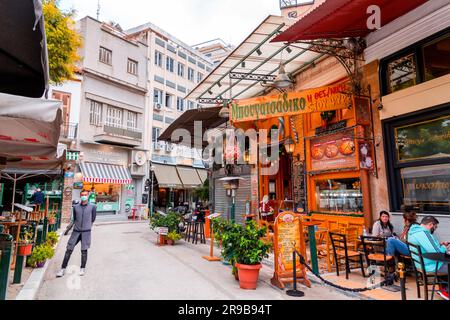 Athen, Griechenland - 25. November 2021: Sitzplätze im Freien in den traditionellen griechischen Restaurants in den zentralen Straßen von Athen, Griechenland. Stockfoto
