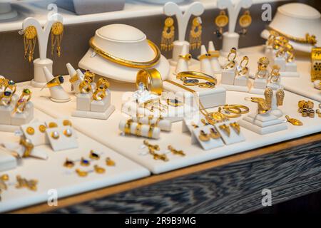 Athen, Griechenland - 25. November 2021: Goldene Accessoires an einem Schaufenster in Athen, Griechenland. Stockfoto