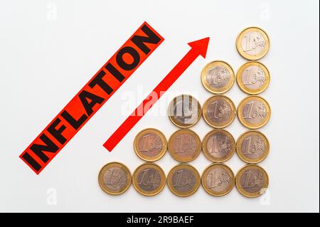 Immer größere Münzreihen, das Wort „Inflation“ und der rote Pfeil zeigen nach oben. Steigende Inflation und Preise. Stockfoto