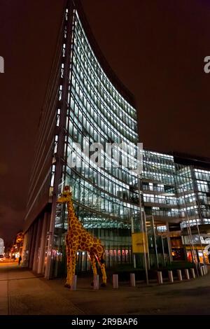 Berlin, Deutschland - 17. DEZ. 2021: Riesige Giraffenstatue vor dem Legoland Discovery Center, Nachtaufnahme in Berlin. Stockfoto