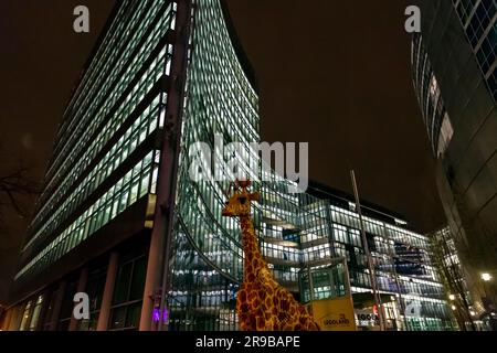 Berlin, Deutschland - 17. DEZ. 2021: Riesige Giraffenstatue vor dem Legoland Discovery Center, Nachtaufnahme in Berlin. Stockfoto