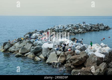 Riomaggiore Italien April 26 2011; Editorial-Rock Uferwand mit jungen Menschen, die die Sonne und die Natur am Meer genießen. Stockfoto