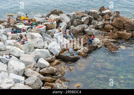 Riomaggiore Italien - 26 2011. April; junge Erwachsene Touristen sonnen und entspannen sich auf dem Pock Pier in der Bucht Stockfoto