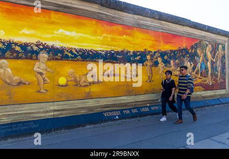 Berlin, Deutschland - 1. Juni 2023: Besucher der kostenlosen öffentlichen städtischen Kunst der East Side Gallery an der öffentlichen Straße in Berlin Stockfoto