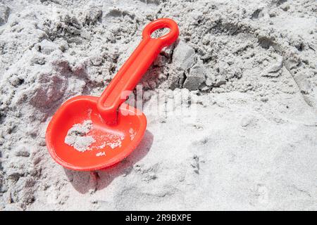 Gebrochene orangefarbene Schaufel am Strand, nicht gespielt, Kopierraum Stockfoto