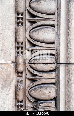 Details aus einer Wand mit alten, griechischen Schnitzereien auf Marmor, strukturierte Hintergrunddetails Stockfoto