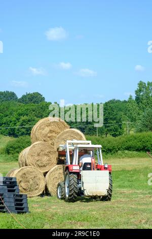 der traktor steyr 650 wird nach der Ernte im ungarischen Bezirk zala zum Stapeln runder Heuballen verwendet Stockfoto