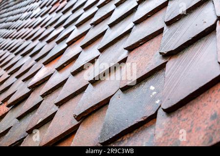 Wandfragment mit mittelalterlichen Keramikfliesen in Diamantform. Strukturierter Hintergrund für architektonische Details. Stockfoto