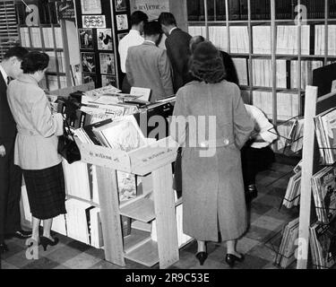 New York, New York: Oktober 1955 Kunden, die das breite Sortiment an RCA Victor und anderen Marken von 78 und 45rpm sowie LP-Platten im Hudson Radio Shop durchstöbern. Stockfoto