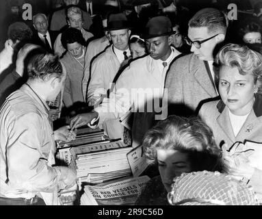 New York, New York: 1962 New Yorker, die sich nach der kubanischen Krise sehnen, kaufen Zeitungen. Stockfoto