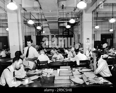 New York, New York: September 1942, die Nachrichtenredaktion der New York Times. Im Vordergrund rechts ist der Herausgeber der Stadt mit seinen zwei Assistenten links. Der City Copy Desk befindet sich in der Mitte, mit dem ausländischen Desk auf der rechten Seite und dem Telegrafenschalter auf der linken Seite. Der Schminktisch befindet sich in der Mitte hinten mit einer Wendeltreppe, die zum Kompositionsraum führt. Kopierleser gehen da hoch, um Proofs zu überprüfen. Stockfoto