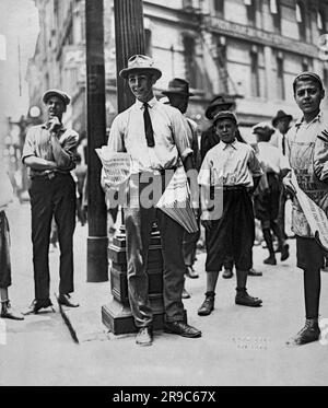 Atlanta, Georgia: ca. 1920 Ein junger Mann, der Zeitungen an der Straßenecke verkauft. Stockfoto