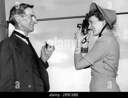 Washington D.C., 1938, eine lächelnde Frau fotografiert ihren Vater, während er für die Kamera posiert. Stockfoto