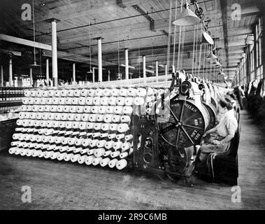 Boston, Massachusetts: 1912 Frauen, die an Beam- und Garninspektionsmaschinen der American Woolen Company arbeiten. Stockfoto