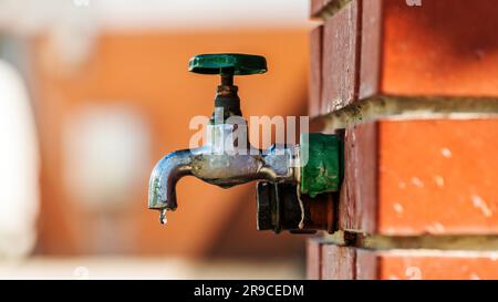 Wasserversorgung, Gartenhahn im Freien mit grünem Griff, selektiver Fokus Stockfoto