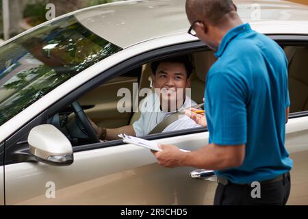 Fahrschulbefehlshaber, der mit dem Schüler spricht, bevor er die Prüfung besteht Stockfoto