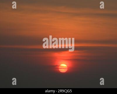 In der Abendsonne am Flussufer sitzen Stockfoto