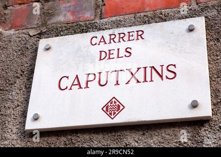 Girona, Spanien - 12. Februar 2022: Straßenschilder aus Keramikfliesen in Girona, Katalonien, Spanien. Carrer del Caputxins. Stockfoto