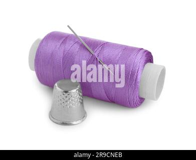 Hülse und Spule aus violettem Nähfaden mit Nadel isoliert auf weiß Stockfoto