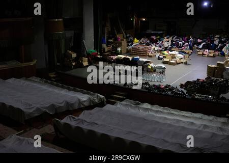 Cherson, Ukraine. 24. Juni 2023. Eine Frau sortierte humanitäre Hilfe für die von der Flut betroffenen Menschen im Kherson Music and Drama Theater von Mykola Kulish in einem Luftschutzbunker in Kherson, Ukraine, am 24. Juni 2023. Der Kakhovka-Staudamm in der Ukraine wurde in den frühen Morgenstunden des 6. Juni 2023 zerstört und verursachte umfangreiche Überschwemmungen entlang des unteren Dnieper-Flusses in der Oblast Kherson. Kredit: Ondrej Deml/CTK Photo/Alamy Live News Stockfoto