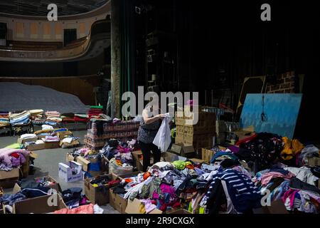 Cherson, Ukraine. 24. Juni 2023. Eine Frau sortierte humanitäre Hilfe für die von der Flut betroffenen Menschen im Kherson Music and Drama Theater von Mykola Kulish in einem Luftschutzbunker in Kherson, Ukraine, am 24. Juni 2023. Der Kakhovka-Staudamm in der Ukraine wurde in den frühen Morgenstunden des 6. Juni 2023 zerstört und verursachte umfangreiche Überschwemmungen entlang des unteren Dnieper-Flusses in der Oblast Kherson. Kredit: Ondrej Deml/CTK Photo/Alamy Live News Stockfoto