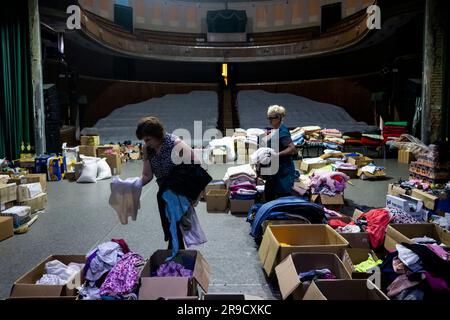 Cherson, Ukraine. 24. Juni 2023. Eine Frau sortierte humanitäre Hilfe für die von der Flut betroffenen Menschen im Kherson Musik- und Drama-Theater von Mykola Kulish in einem Bombenbunker in Kherson, Ukraine, am 24. Juni 2023. Der Kakhovka-Staudamm in der Ukraine wurde in den frühen Morgenstunden des 6. Juni 2023 zerstört und verursachte umfangreiche Überschwemmungen entlang des unteren Dnieper-Flusses in der Oblast Kherson. Kredit: Ondrej Deml/CTK Photo/Alamy Live News Stockfoto