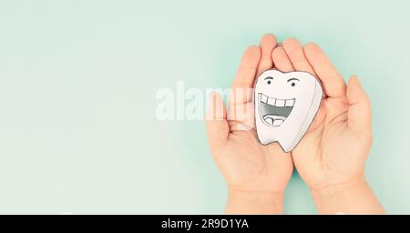 Weißer Zahn mit lächelndem Gesicht und Daumen hoch, Zahngesundheit, Zahnhygiene, medizinisches Konzept Stockfoto